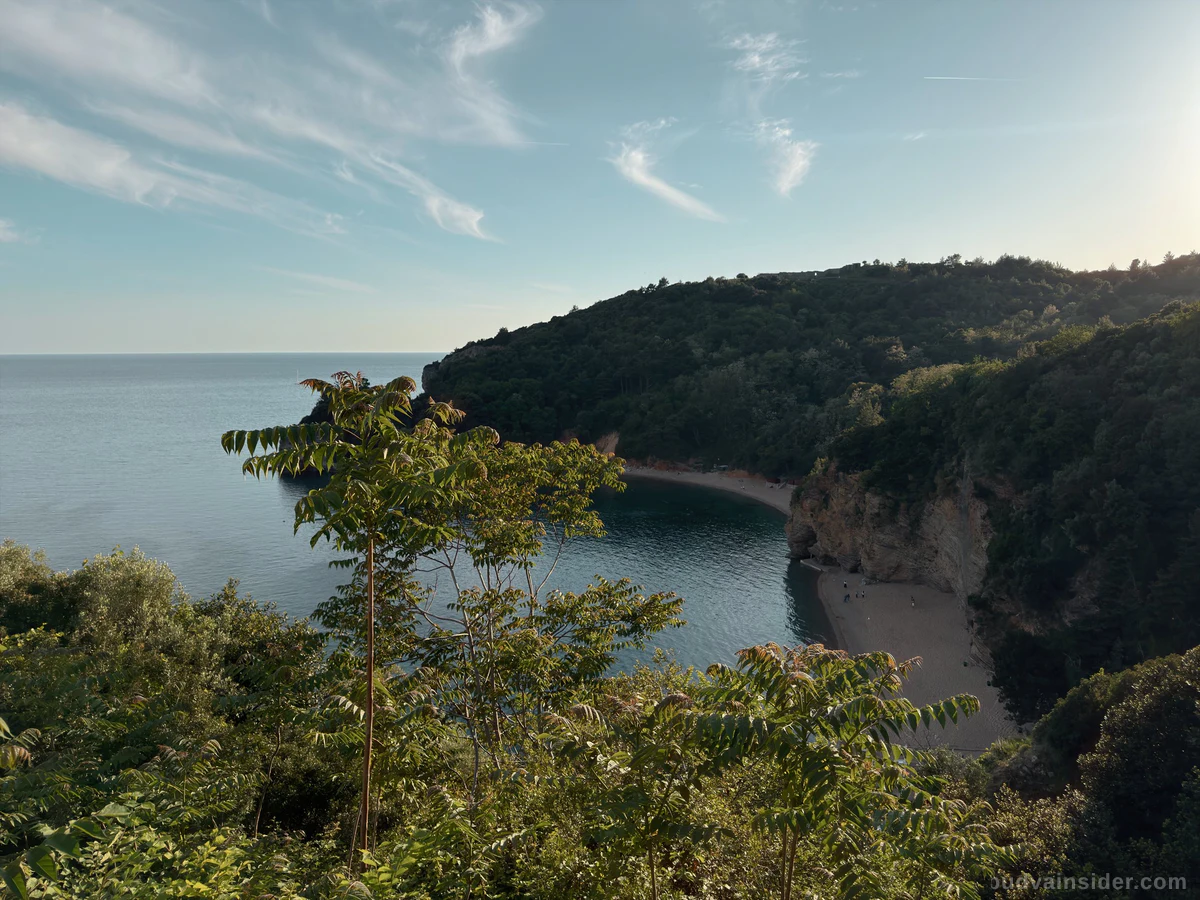 Mogren beach, a cliff-backed cove of sand and pebble near Budva's Old Town