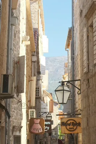 A marble-paved lane inside Budva's walled Old Town at golden hour